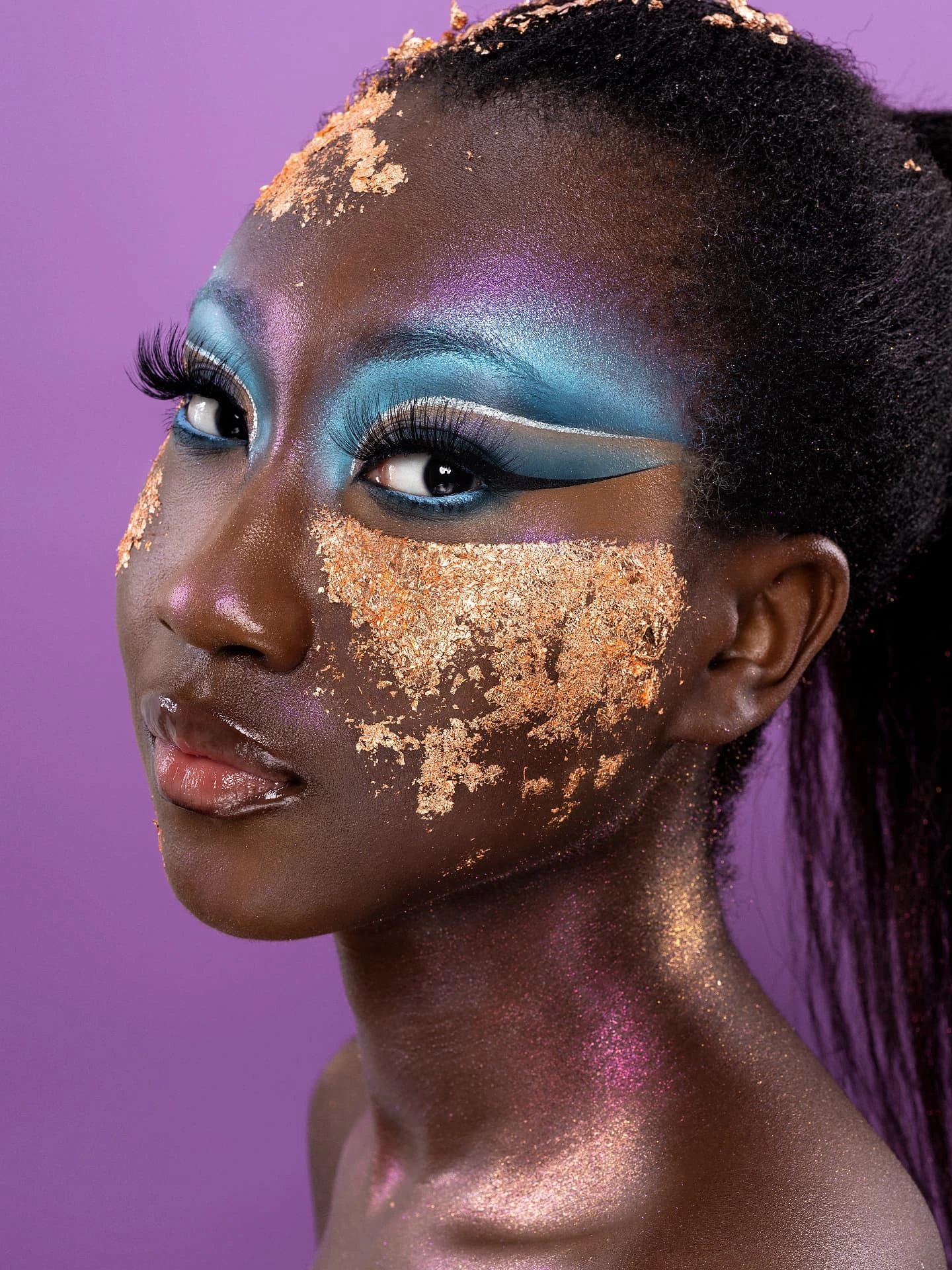 Beauty creativo con decorazioni metalliche dorate e trucco turchese e viola